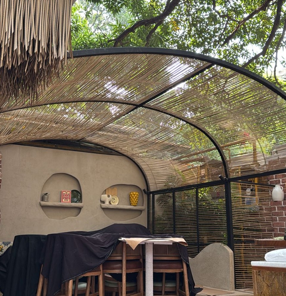 Bamboo arc-weave canopy over a rustic dining setting