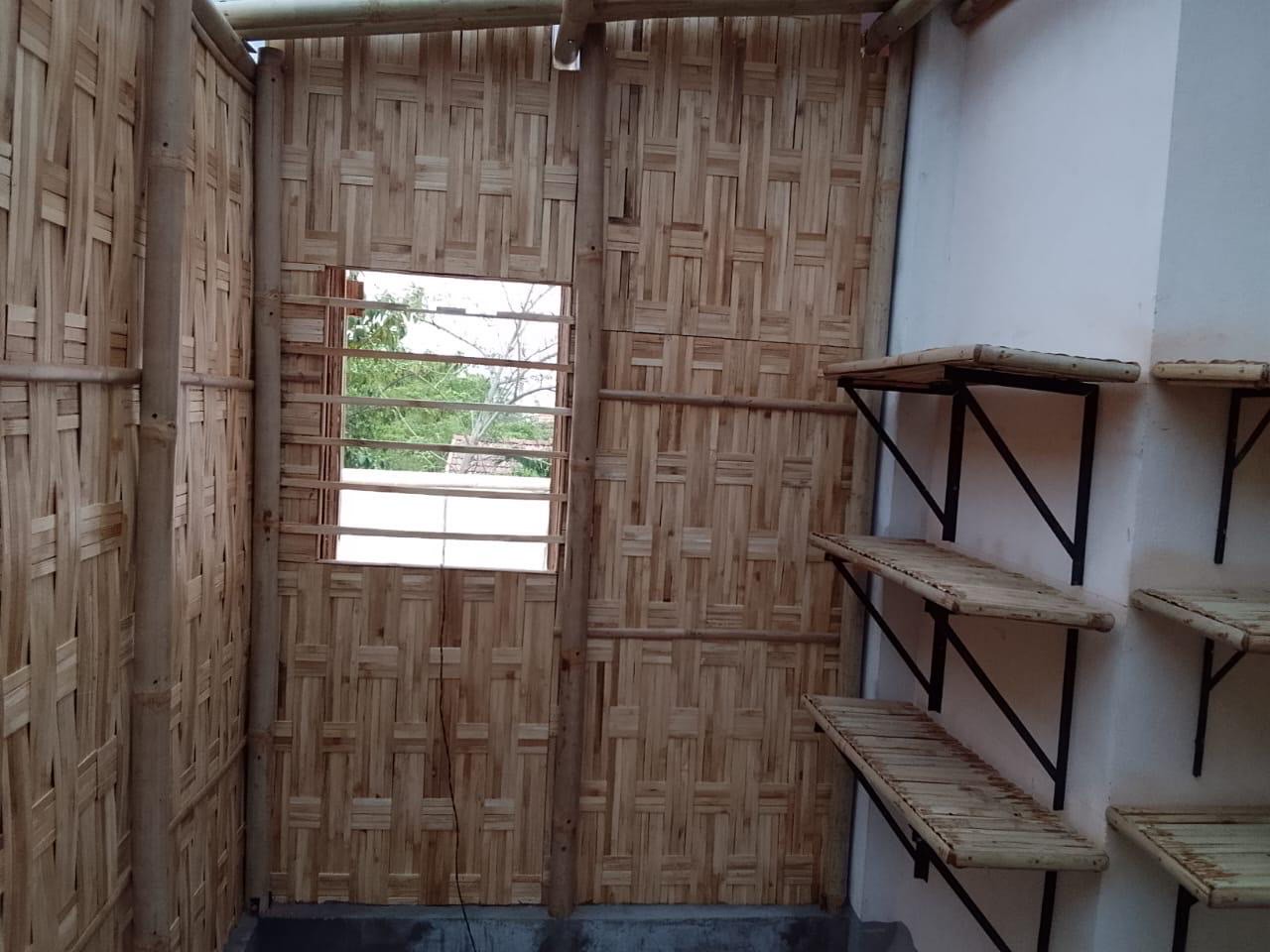 Bamboo woven wall panels enclosing a rooftop studio with shelving, Hyderabad
